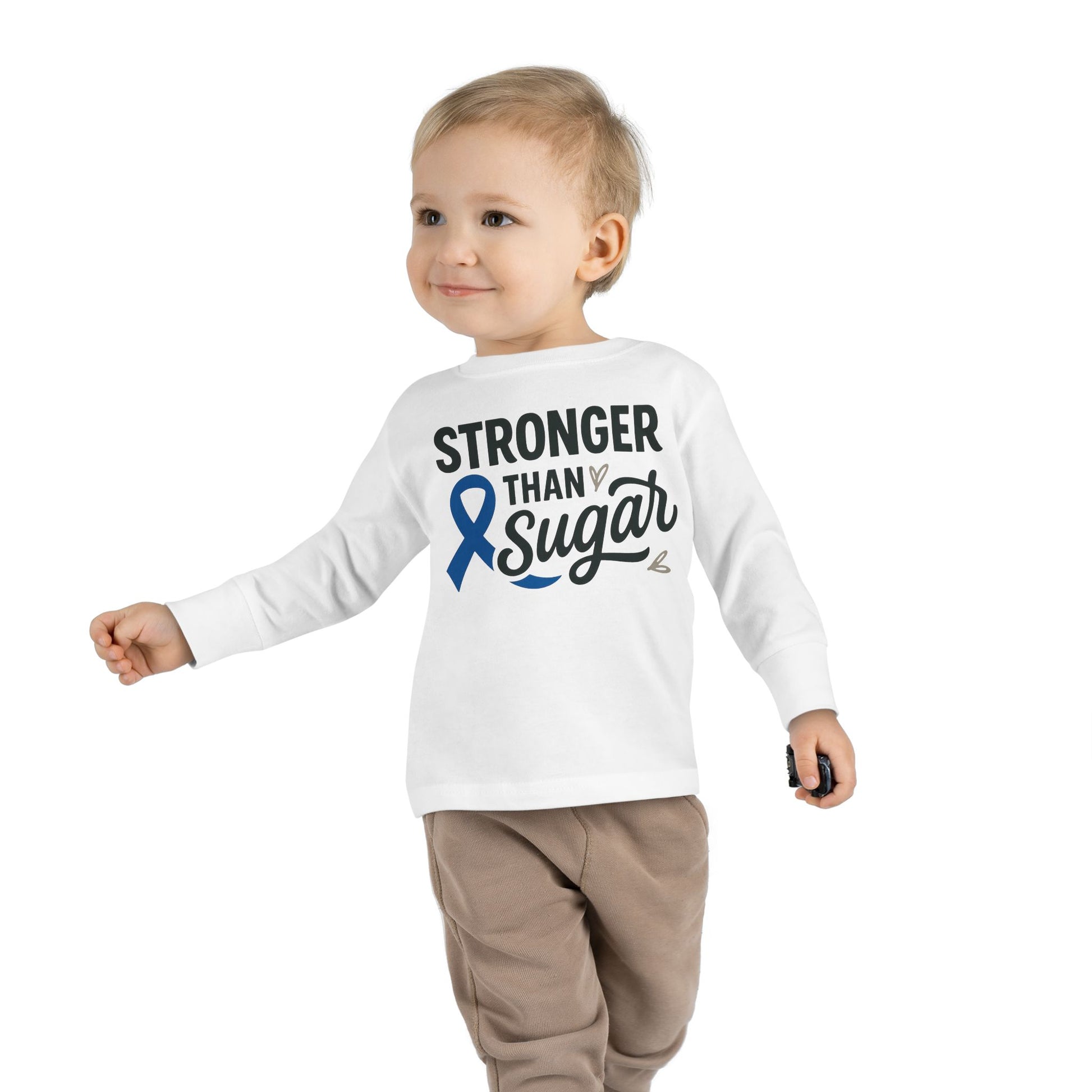 Toddler boy wearing white Stronger Than Sugar long sleeve shirt — kids awareness top with blue diabetes ribbon symbolizing health and resilience.