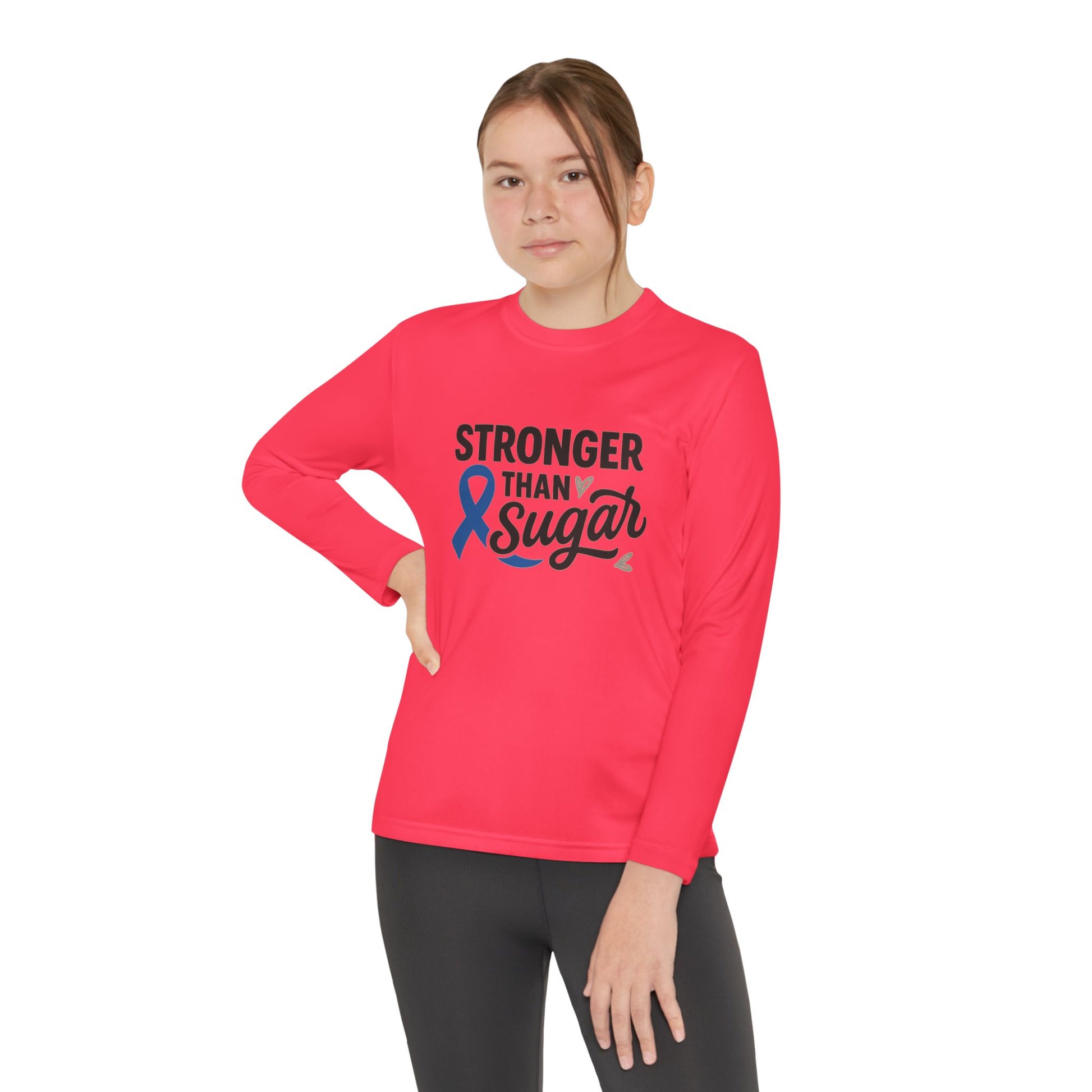 Youth girl wearing hot coral Stronger Than Sugar long sleeve — motivational awareness tee promoting diabetes advocacy, strength, and hope.