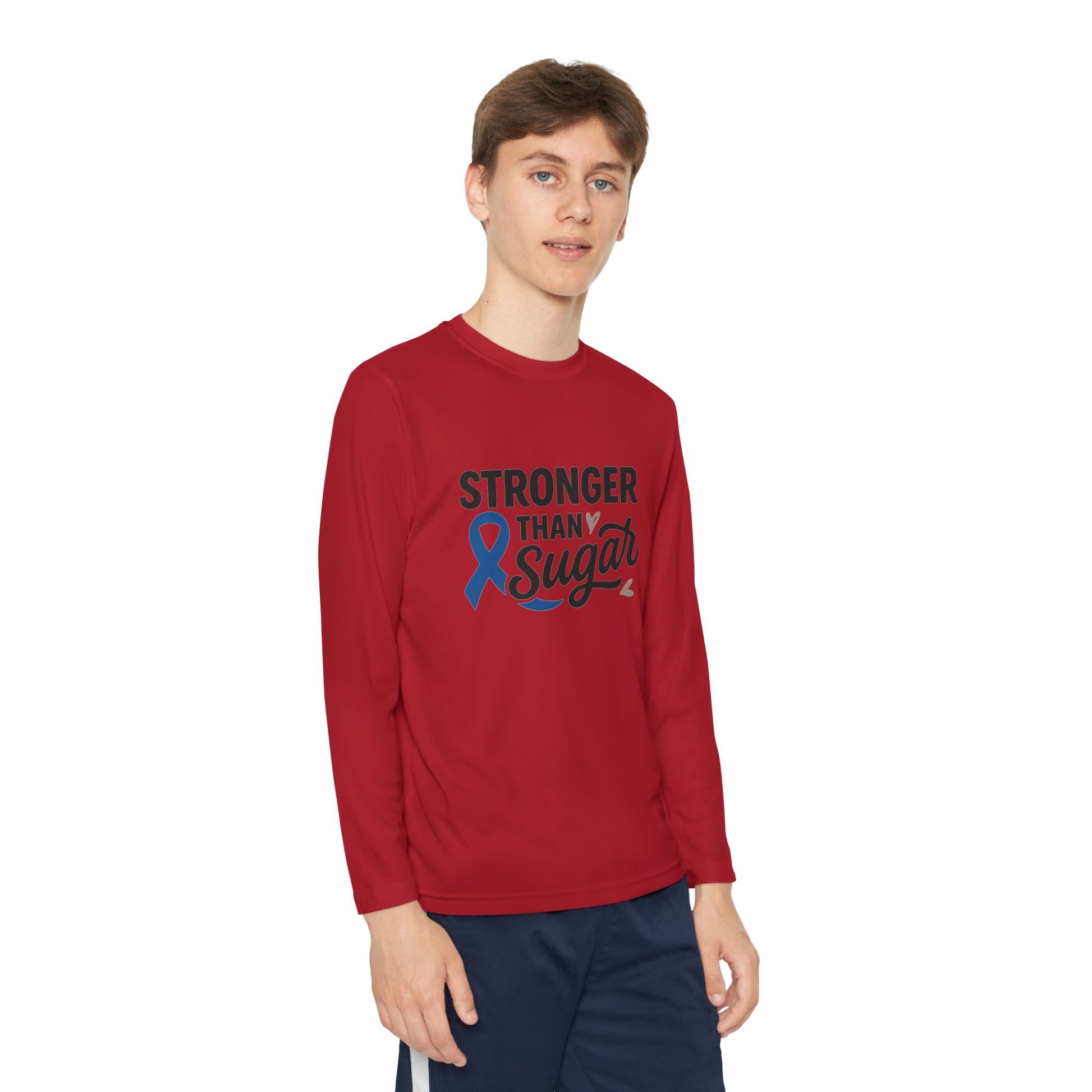 Youth boy wearing true red Stronger Than Sugar long sleeve shirt — inspiring diabetes awareness top featuring blue ribbon and message of strength.