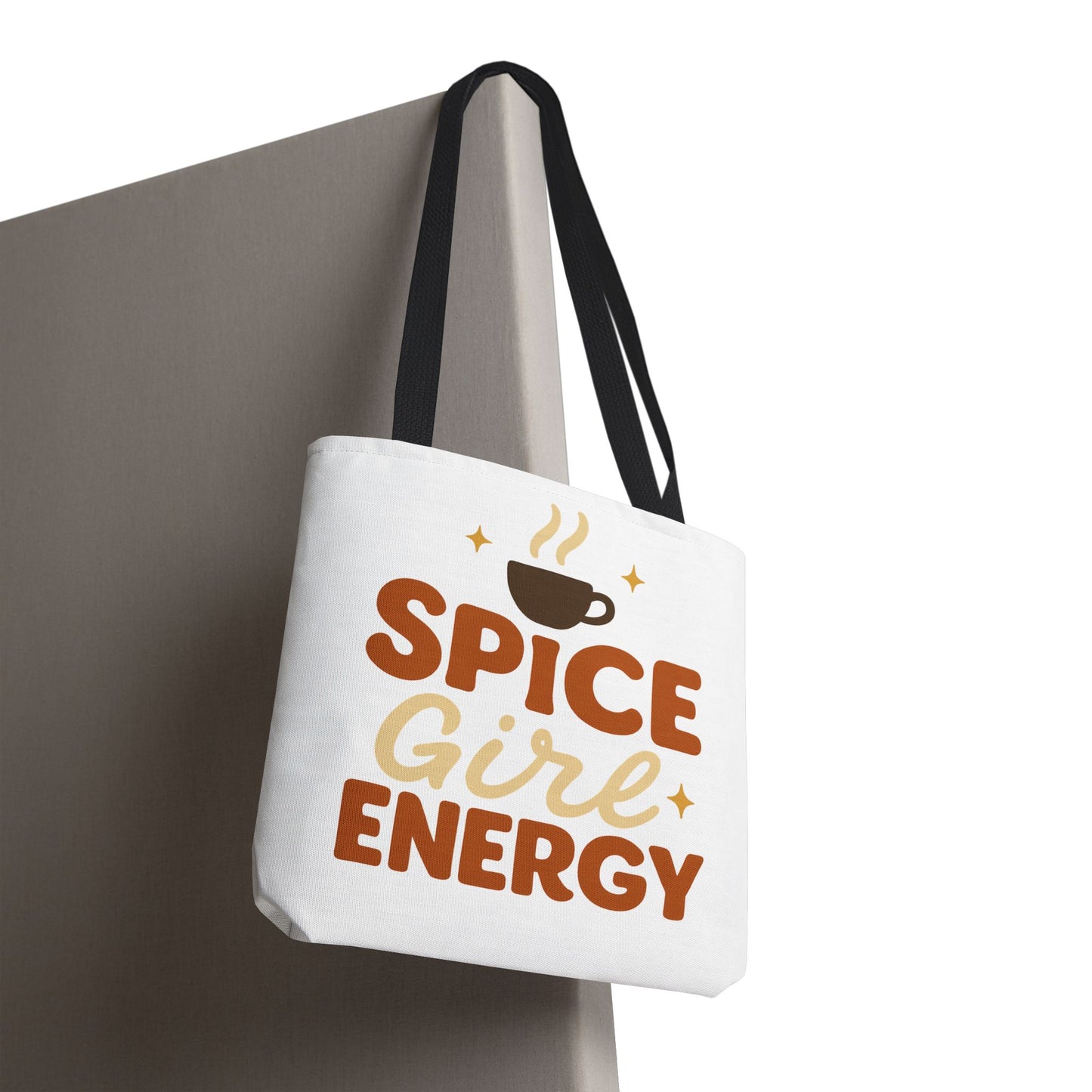 White “Spice Girl Energy” tote bag with black straps hanging on wall — trendy coffee-themed tote perfect for fall and everyday use.