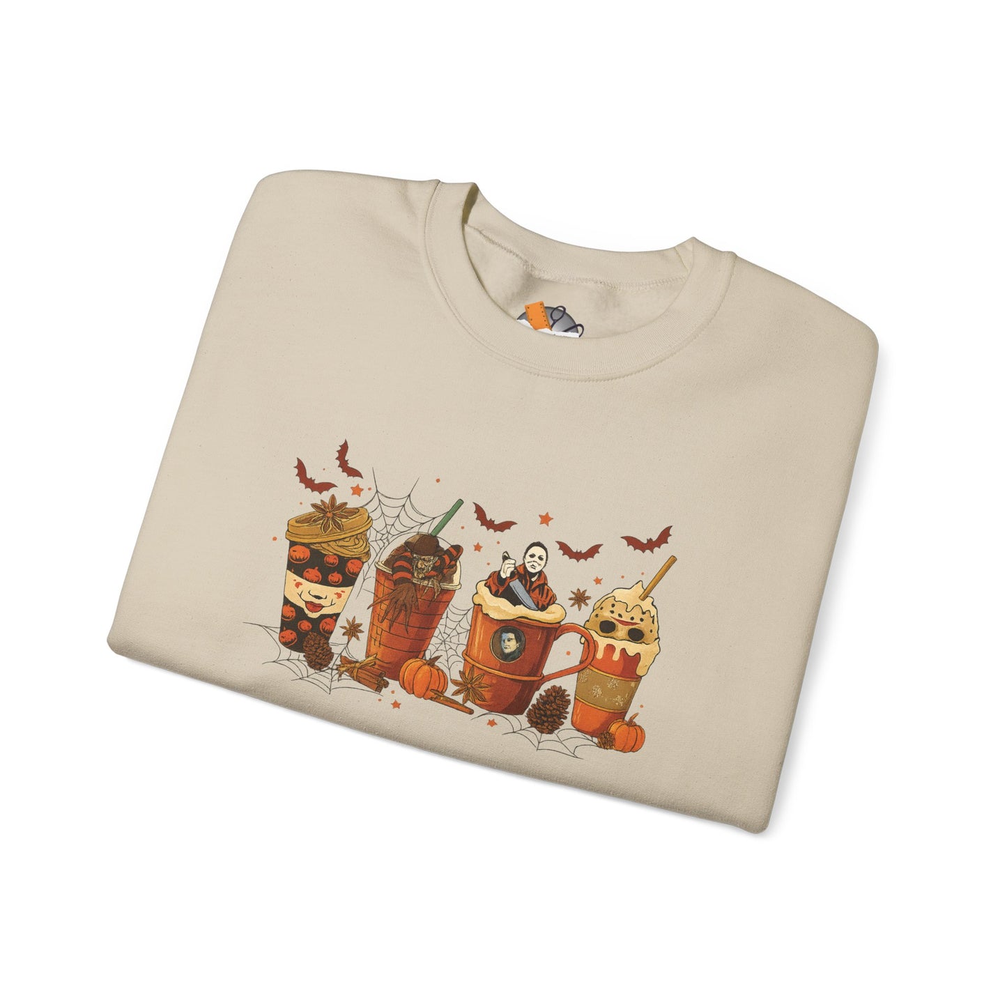 Folded sand beige Gildan 18000 crewneck sweatshirt with Halloween horror coffee drinks graphic featuring spooky cups and bats.
